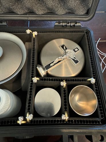 Metal religious items including a crucifix in a padded case.