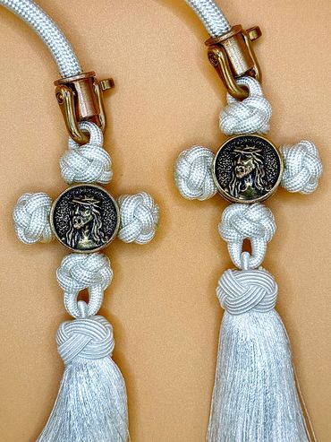 Two white tassel crosses with Jesus medallions.
