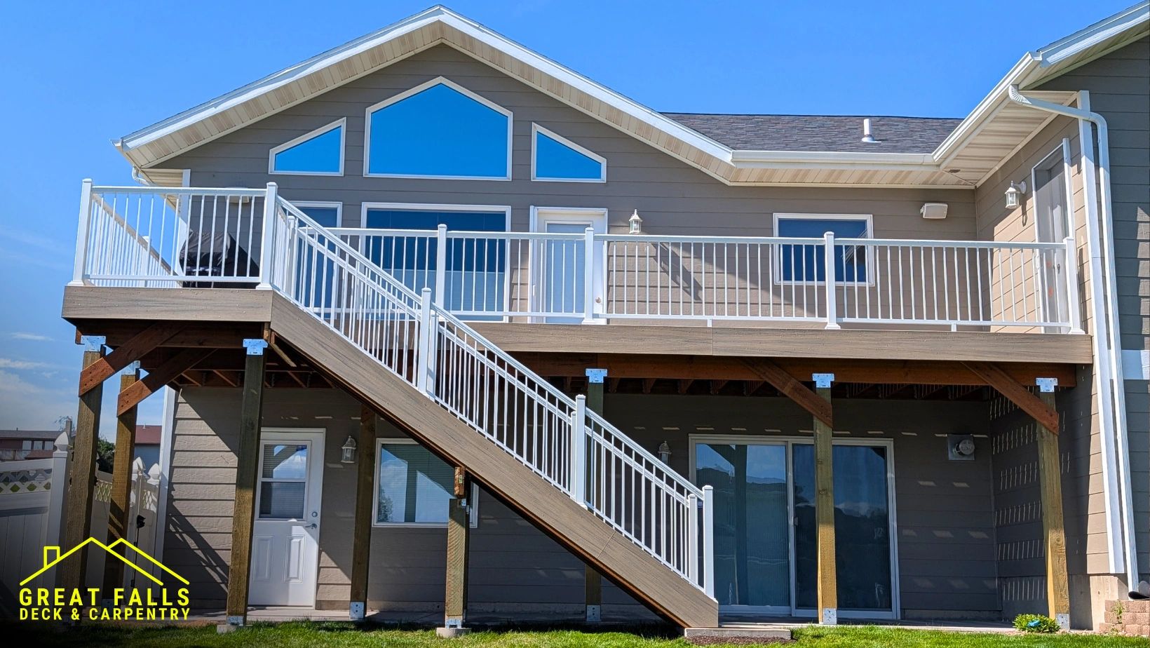 Modern elevated deck with white railing and stairs on a residential home.