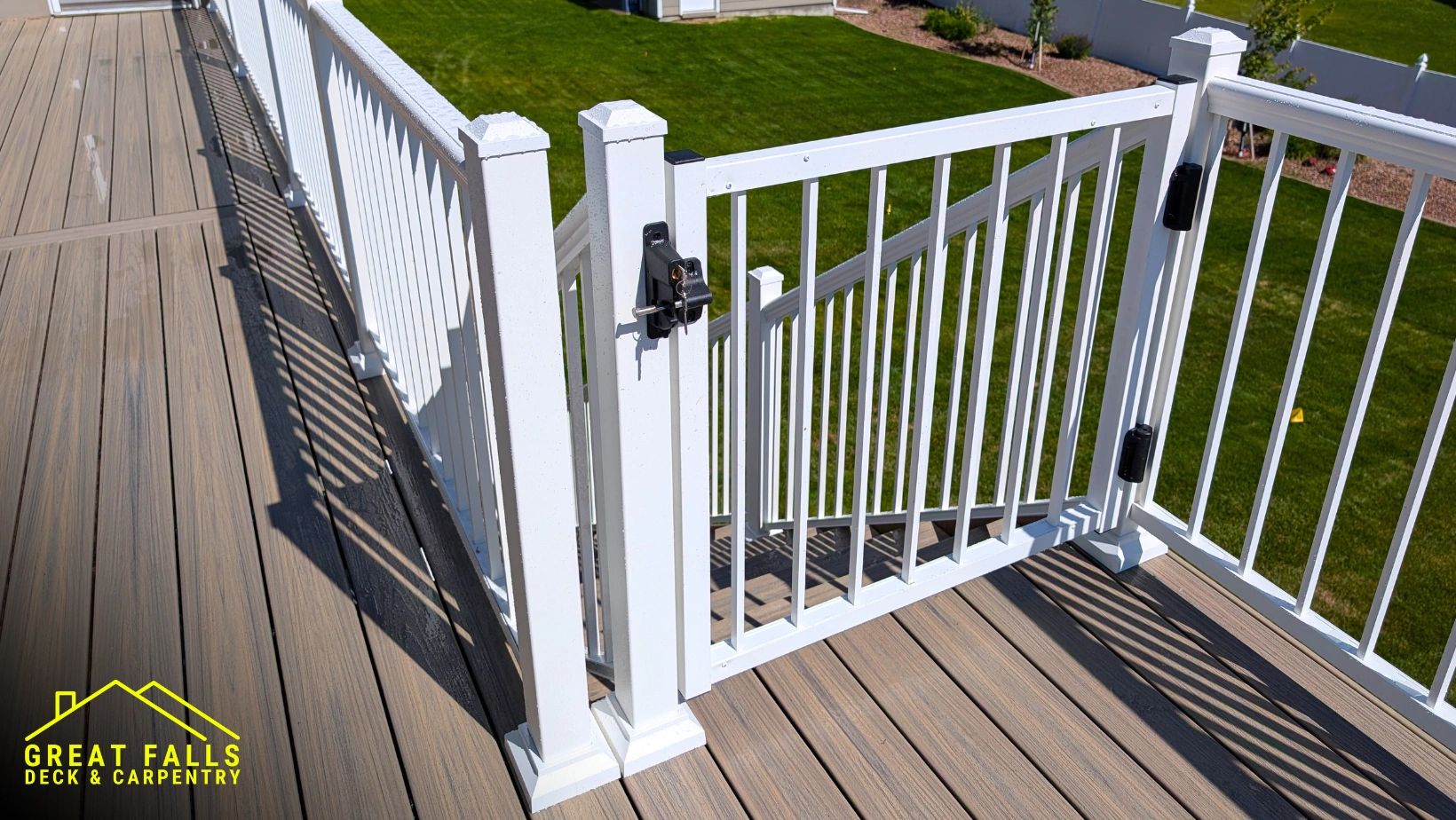 White deck gate with latch overlooking a green lawn.