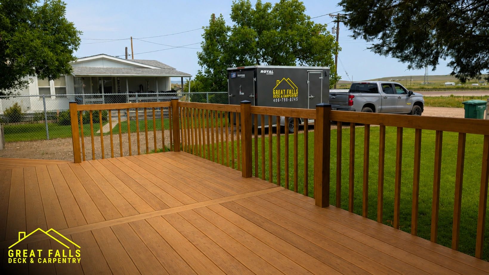 New wooden deck with railing in a backyard.