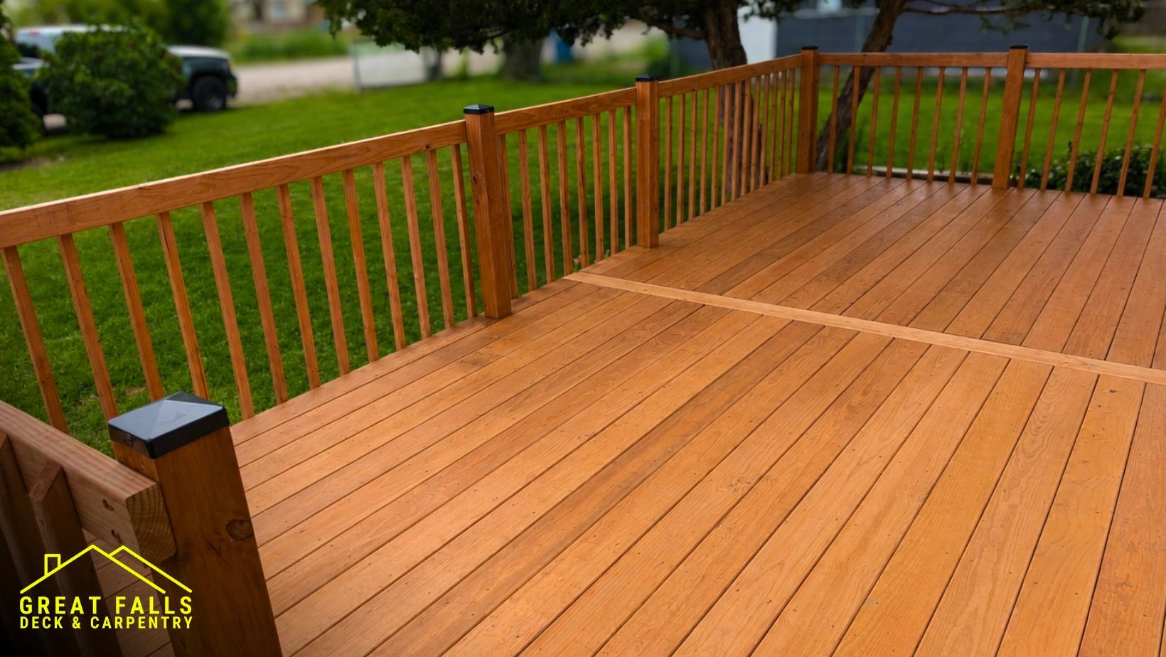 Newly constructed wooden deck with railing and green lawn.