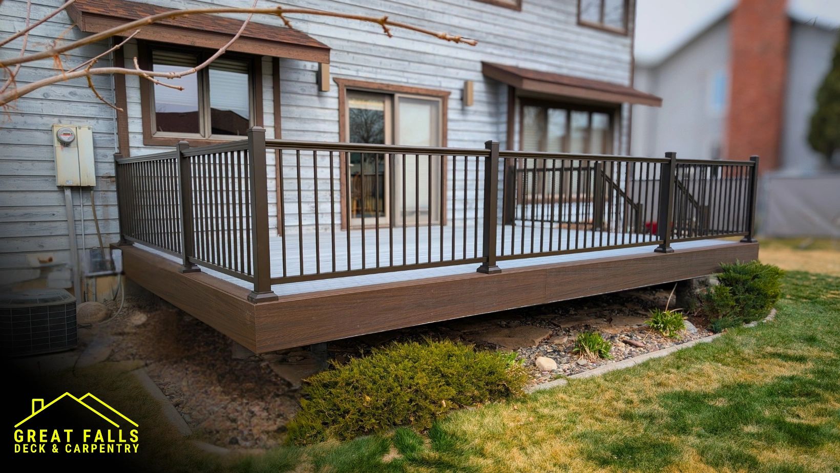Modern wooden deck with metal railing attached to a house.