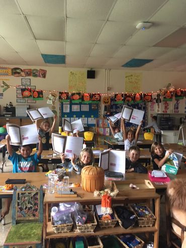 students showing their activity books