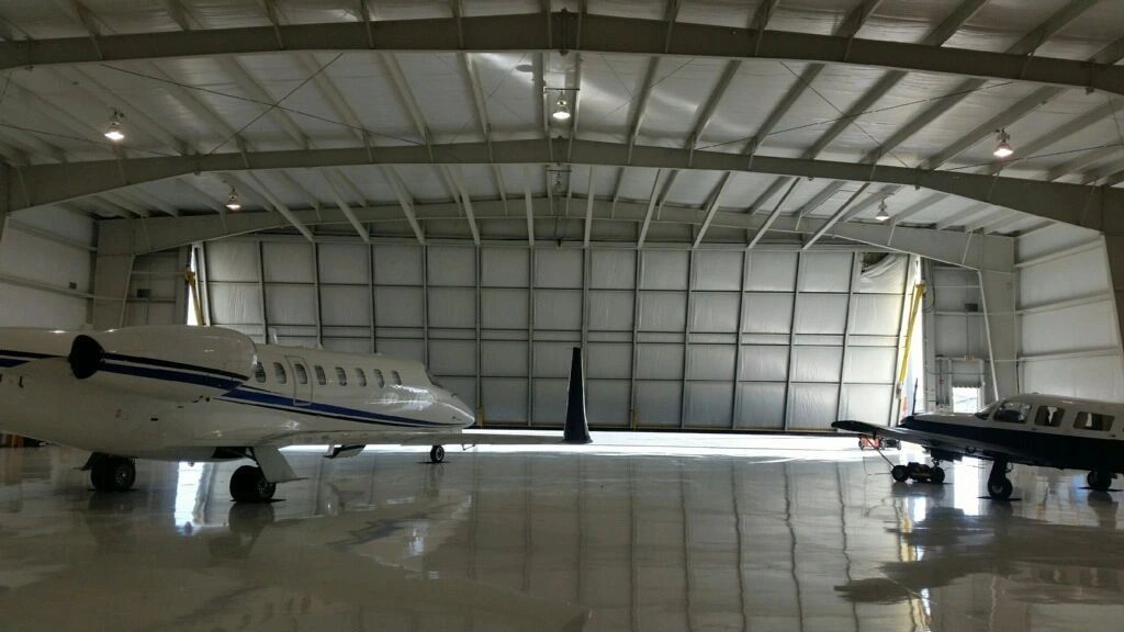 Two airplanes parked inside a spacious hangar.