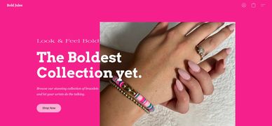 Close-up of hands wearing a diamond ring and colorful bracelets with pink nails.