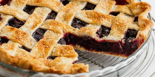 A freshly baked cherry pie with a lattice crust and sugar topping.