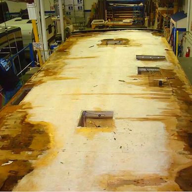 A large, weathered surface undergoing restoration in a workshop.