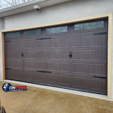 A closed brown garage door with decorative handles and hinges.