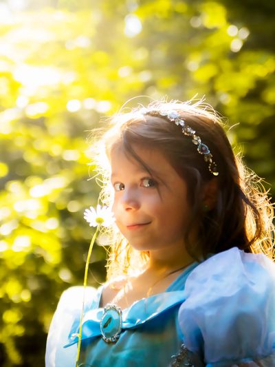 A young girl in the forest holding a daisy with natural light, photography in Northern California 