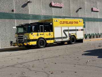 Yellow Cleveland Township fire truck parked outside a building.