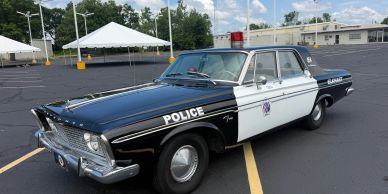 Vintage police car parked in an empty lot.