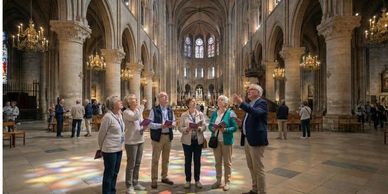 A group of tourists listening to a guide inside a grand cathedral.
