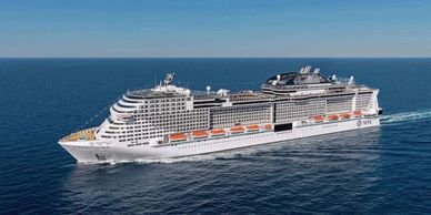 A large white cruise ship sailing on calm blue ocean waters.