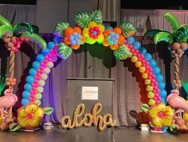 Luau themed balloon arch, balloon palm trees, stage decor