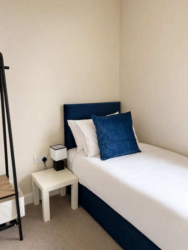 Neat bedroom with blue and white bed linens.