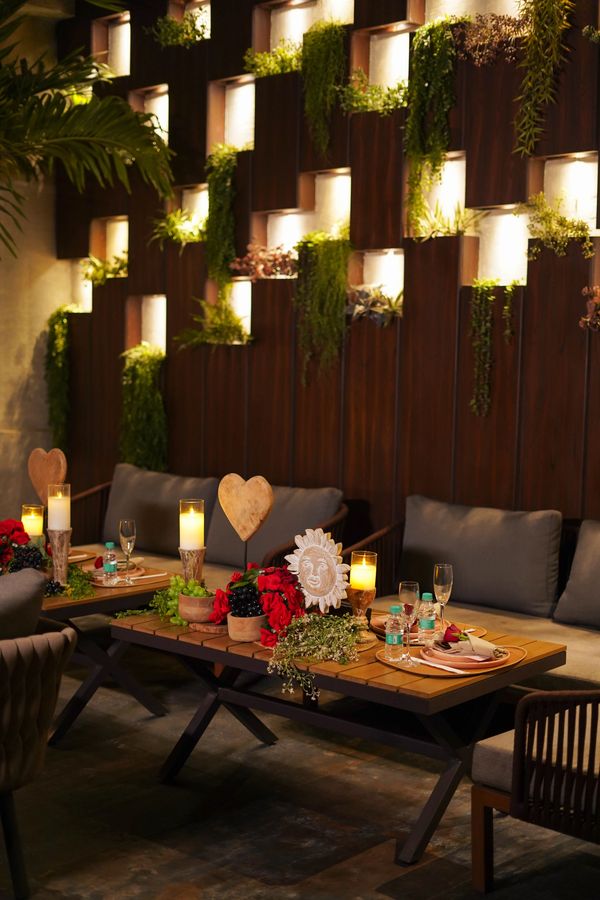 Cozy dining area with warm lighting, greenery, and elegant table settings.