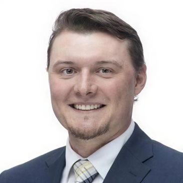 Professional headshot of a smiling man in a suit.