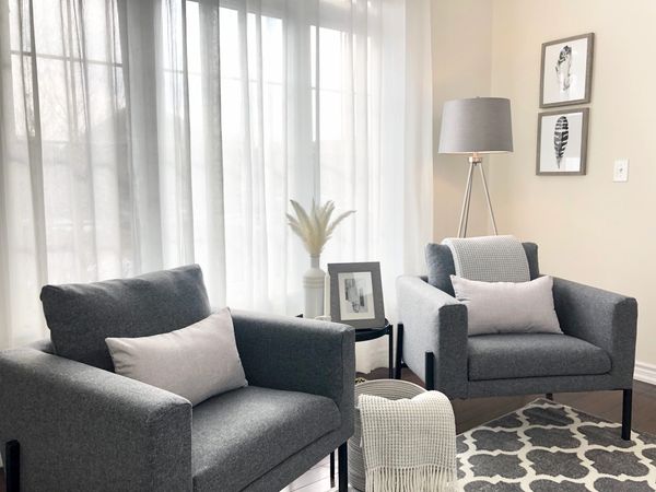 Grey accent chairs in a monochromatic colour story  with white ceramic accessories