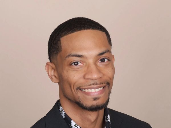 Smiling man with short hair and a goatee.