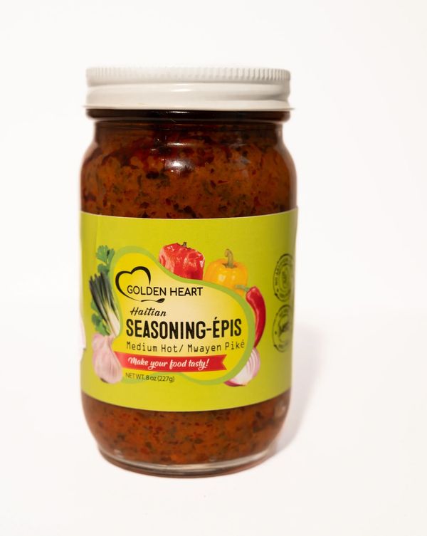 Jar of Taïna Haitian Epis Medium wet seasoning paste, vibrant Caribbean herbs visible