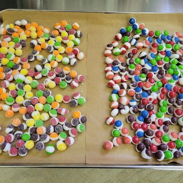Two trays of colorful, round candies with various patterns and colors.