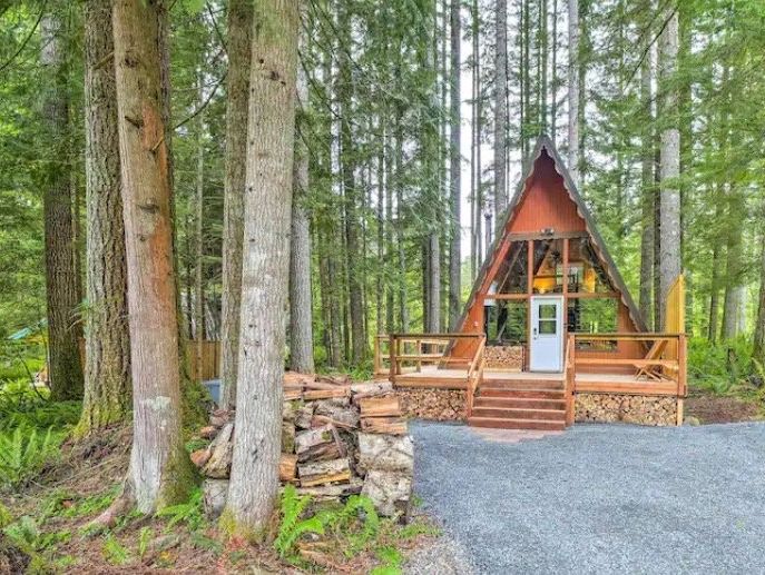 Cozy cabin in evergreens near Mt Rainier, WA. Firelight, hot tub, trails. Weekend warmth awaits you.