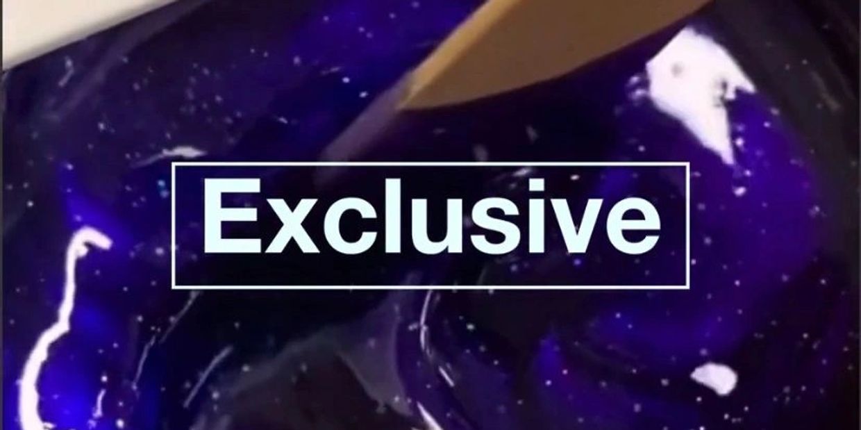 Close-up of a dark blue liquid with the word 'Exclusive' overlaid.