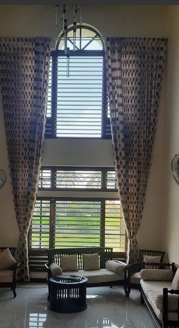 Living room with tall windows and patterned curtains.