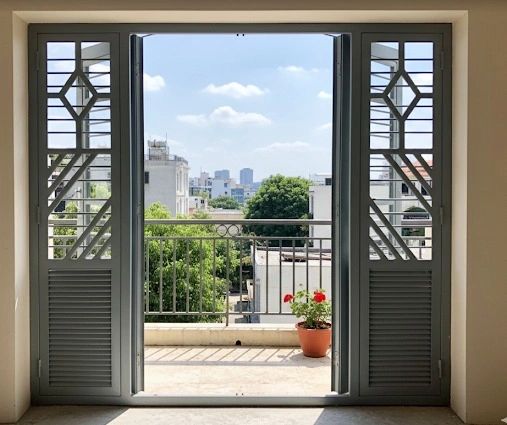 Open door leading to a balcony with city view.