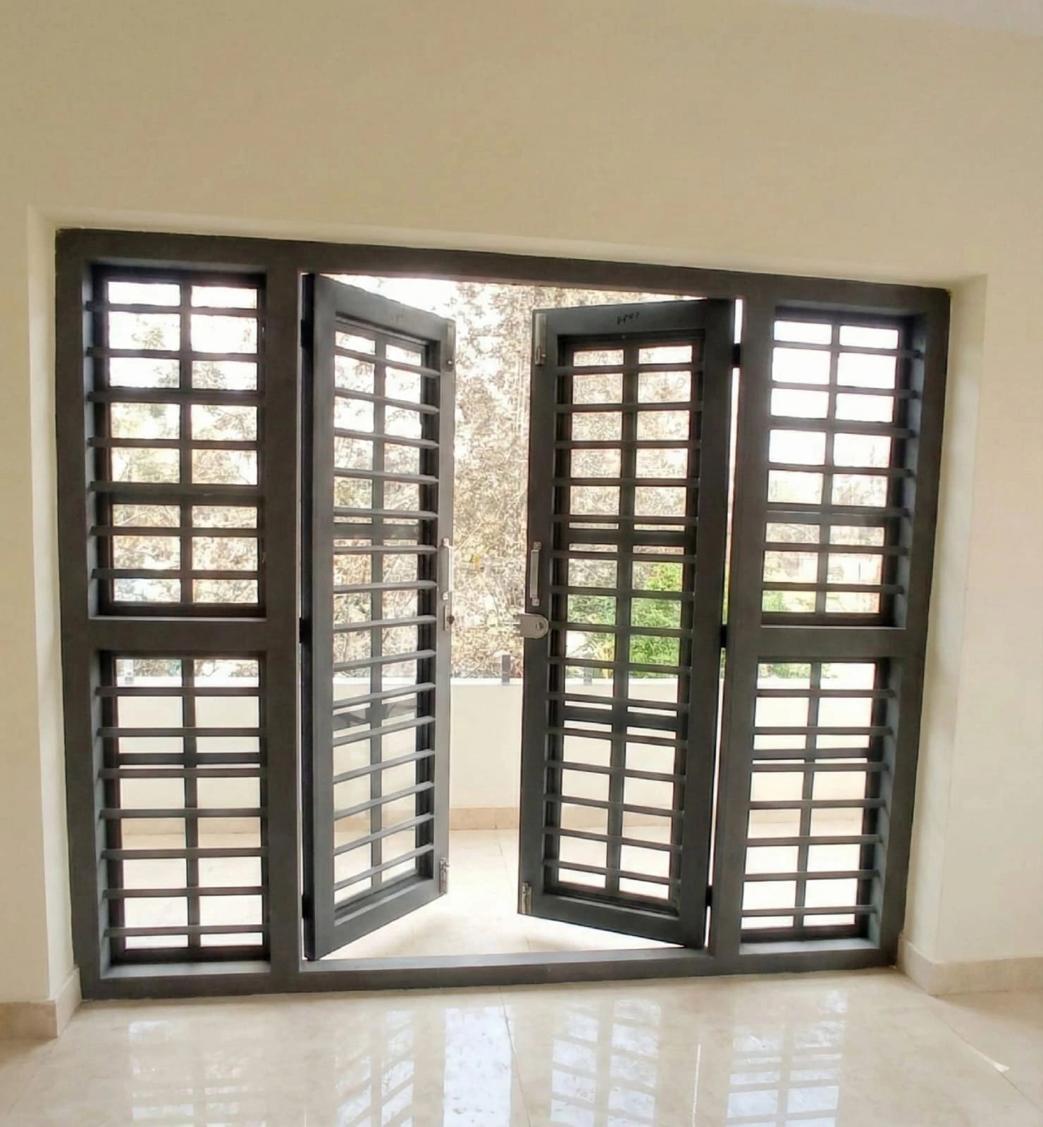 Modern black metal security door with glass panels.