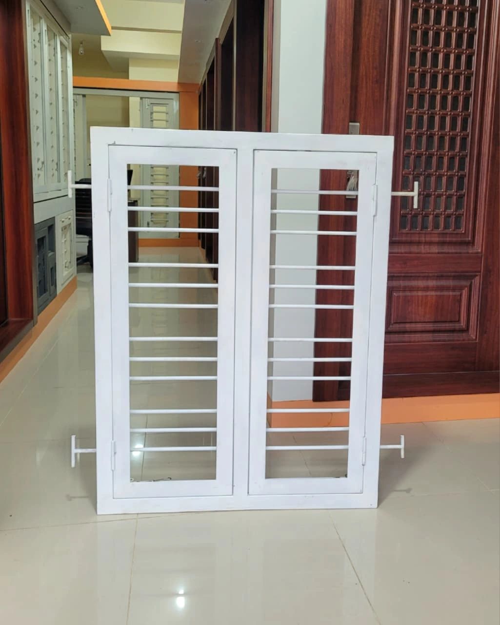 White metal window grill with horizontal bars and two panels.