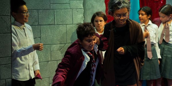 Children dressed as Harry Potter characters acting in a school play.