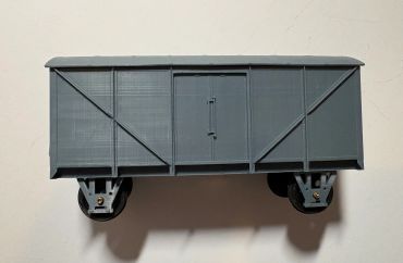 Gray model train boxcar on plain background.