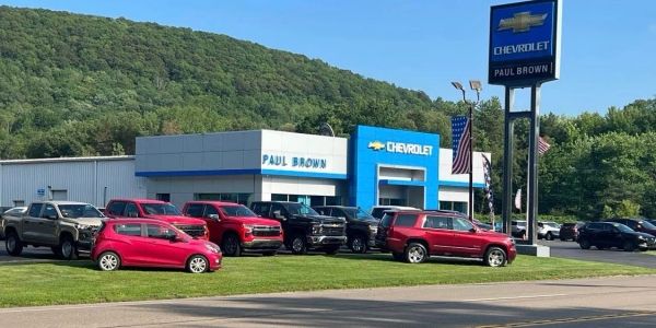 Chevrolet dealership with various vehicles parked outside on a sunny day.