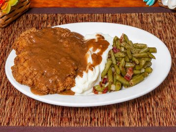 Fried steak with mashed potatoes and green beans.
