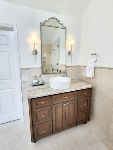 Elegant bathroom vanity with round sink and decorative mirror.