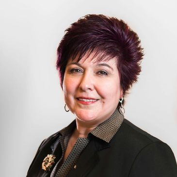 Professional woman with short dark hair in business attire.