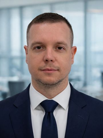 Professional man in a suit and tie with a neutral expression.