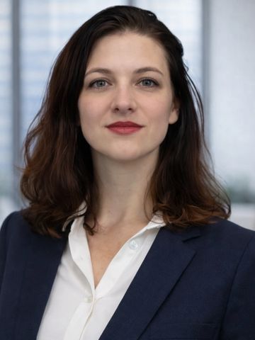 Professional woman in business attire posing confidently.