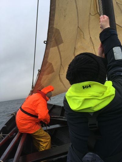 Crew members hoisting the sail on the Shetland sixareen Vaila Mae.