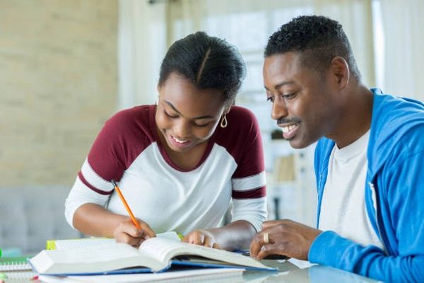 a man and woman looking at a book 