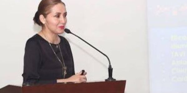Woman speaking at a podium with a microphone.