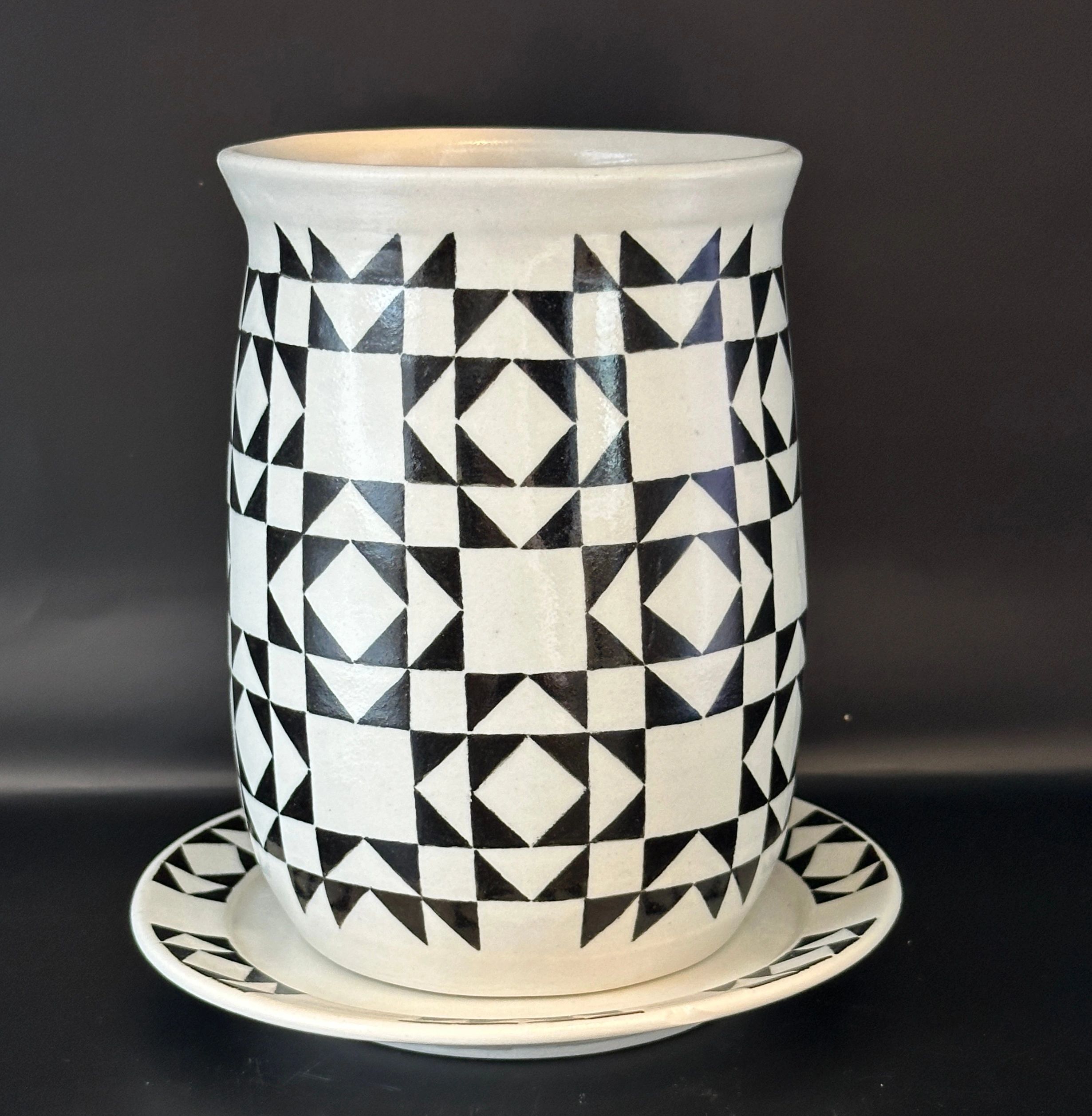 Black and white geometric patterned cup with matching saucer.