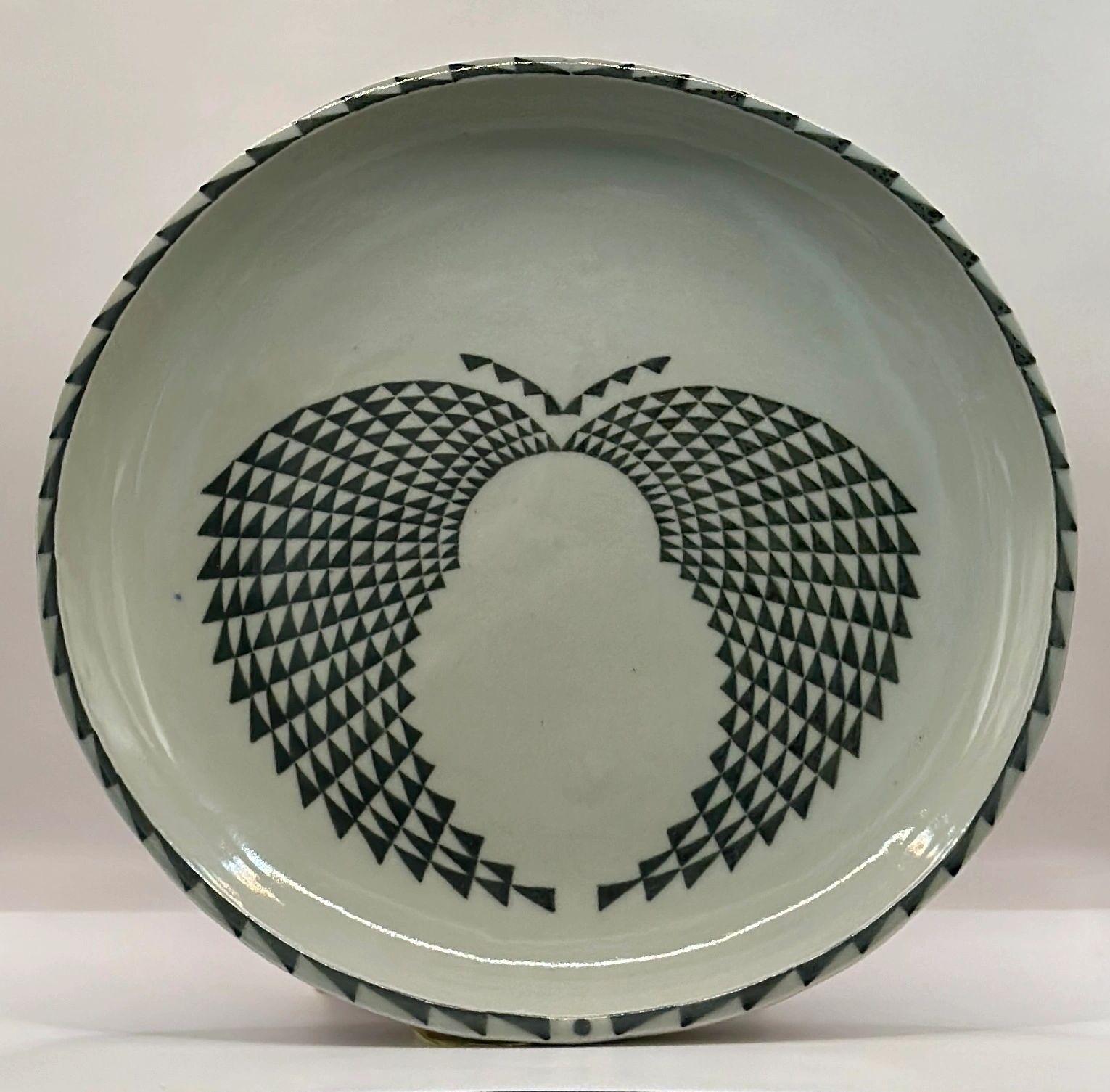 White plate with black geometric butterfly design.