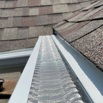 Close-up of a clean roof gutter with protective mesh.