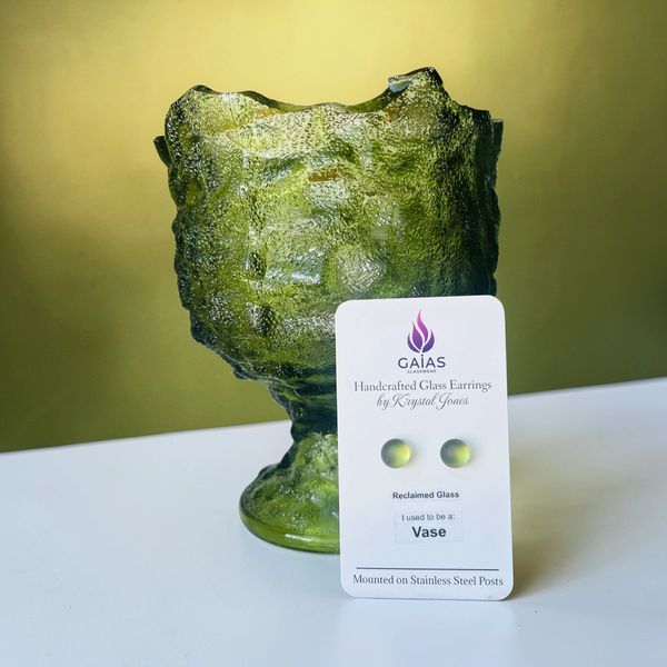 Green glass vase turned into handcrafted earrings, displayed on a card.