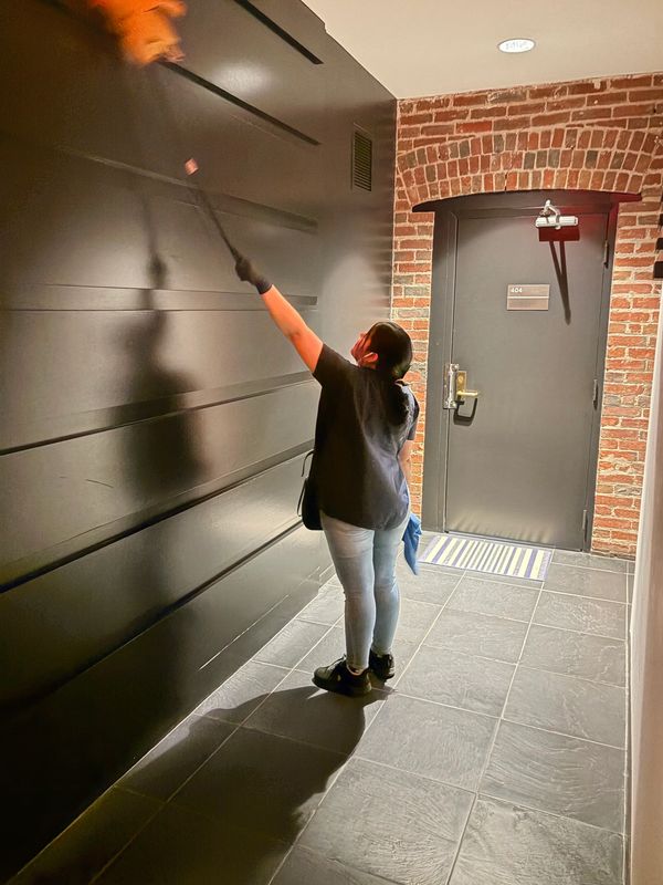 Person dusting wall.