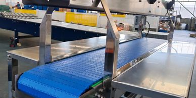 Blue conveyor belt system in an industrial setting.