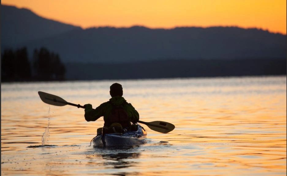 Paddling a Kayak at sunset.